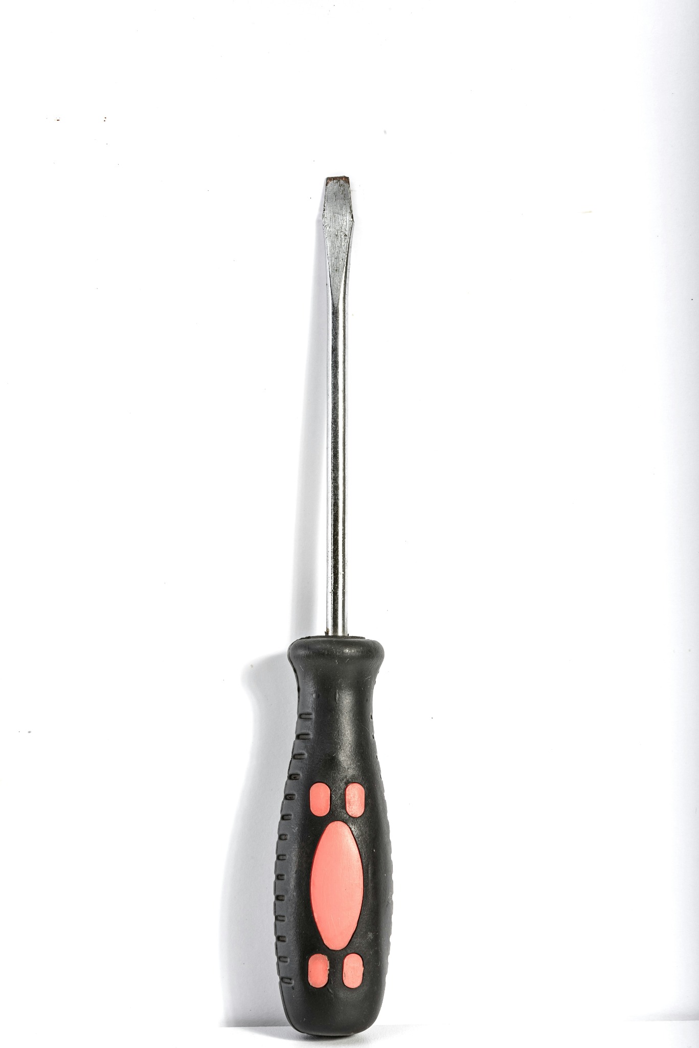 Płaski śrubokręt z czarną rękojeścią z pomarańczowymi wstawkami, leżący na białym tle.