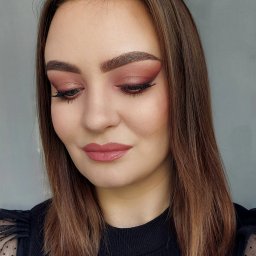 Iga Czajkowska - Portret kobiety z delikatnym, różowym makijażem oczu i ust. Widoczne staranne wykończenie i dbałość o detale, ciemna bluzka z siateczkowymi rękawami.