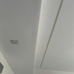 BudMex - Biały sufit z dekoracyjnym wgłębieniem i oświetleniem punktowym. Minimalistyczny design, gładka powierzchnia, nowoczesne wykończenie wnętrza.