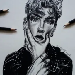 Czarno-biały portret osoby z piercingiem i mocnym makijażem, wykonany ołówkiem na papierze, z widocznymi ołówkami obok rysunku.