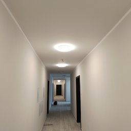 Gładzie szpachlowe, gruntowanie i malowanie wraz z instalacją oświetlenia i montażem drzwi do mieszkań. Razem ponad 1600 m2