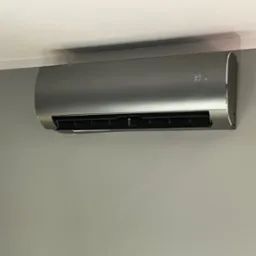 Zamontowany na ścianie, szary klimatyzator z wyświetlaczem pokazującym temperaturę 30 stopni Celsjusza.