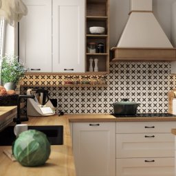 Artimagine sp. z o.o. - Jasna kuchnia z drewnianymi blatami i czarno-białą mozaiką na ścianie, wyposażona w nowoczesne sprzęty i dekoracje, w tym wieniec nad oknem i świeżą kapustę na blacie.