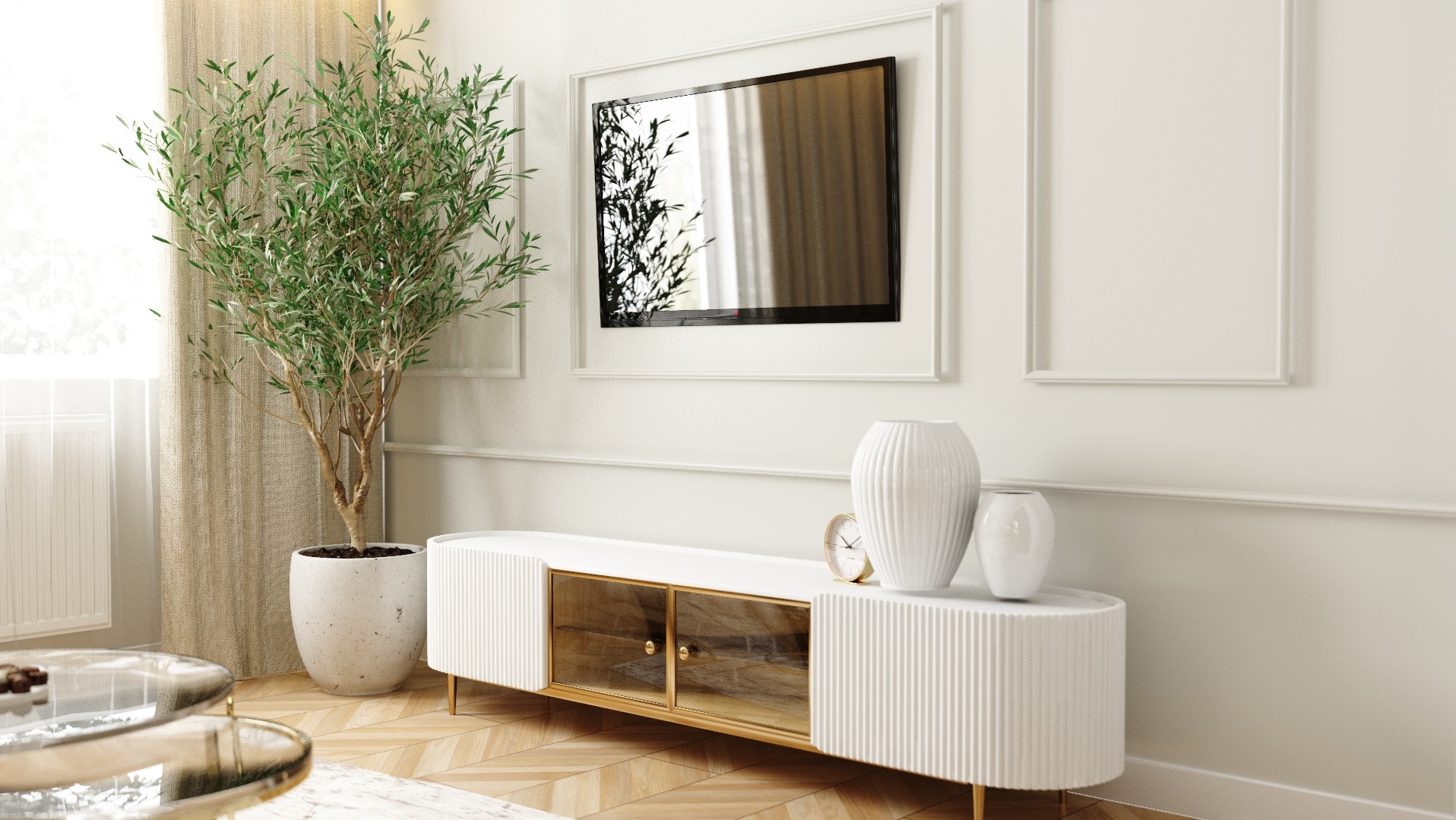 Jasne wnętrze salonu z telewizorem w ramie, rośliną w donicy i białą szafką RTV z dekoracjami, wazonami i złotym zegarem.