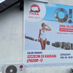 Mateusz Góral - Zewnętrzna jednostka klimatyzacji LG zamontowana pod banerem reklamowym biura podróży Itaka, z ofertą zimowych wyjazdów do Malezji-Langkawi.