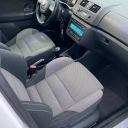 MarClean Pranie Tapicerek - Wnętrze samochodu Skoda Fabia Monte Carlo z szaro-czarną tapicerką, widok na fotele, deskę rozdzielczą i kierownicę, z zawieszką zapachową Wunder-Baum. Widoczny napis Monte Carlo na progu.