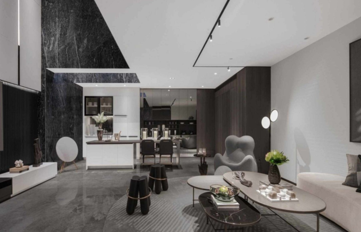 Nowoczesny salon z czarnym marmurem na ścianie, oświetleniem szynowym na białym suficie i szarymi meblami