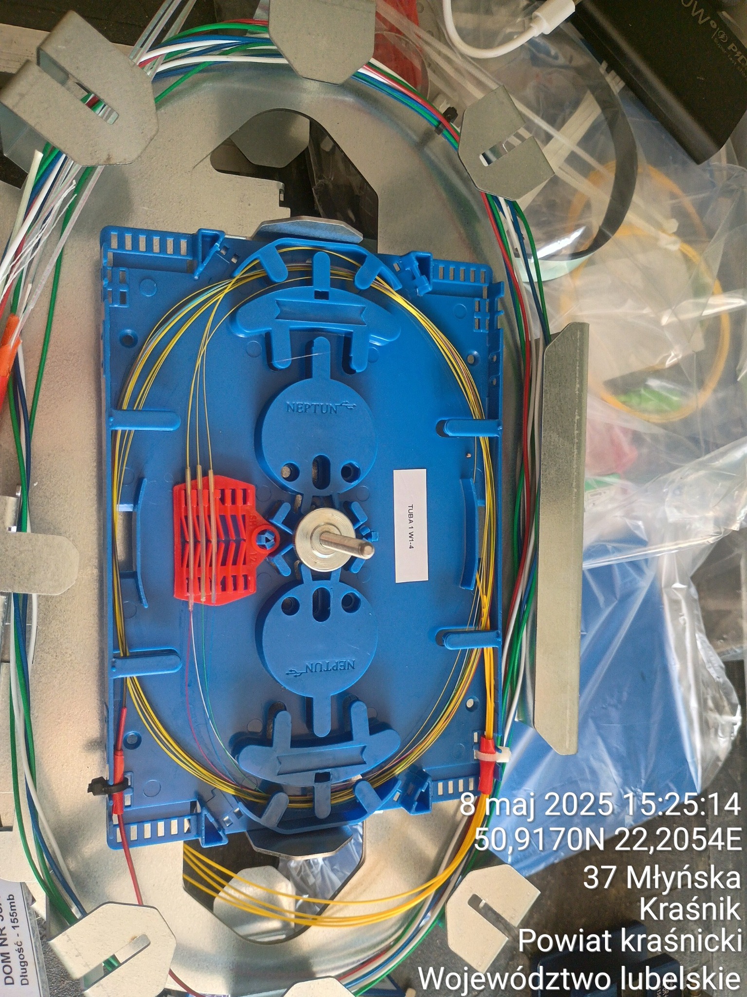 Splice box światłowodowy w Sokołowie Małopolskim. Niebieska kaseta światłowodowa z włóknami wewnątrz metalowej obudowy. Widoczne kable i złącza.