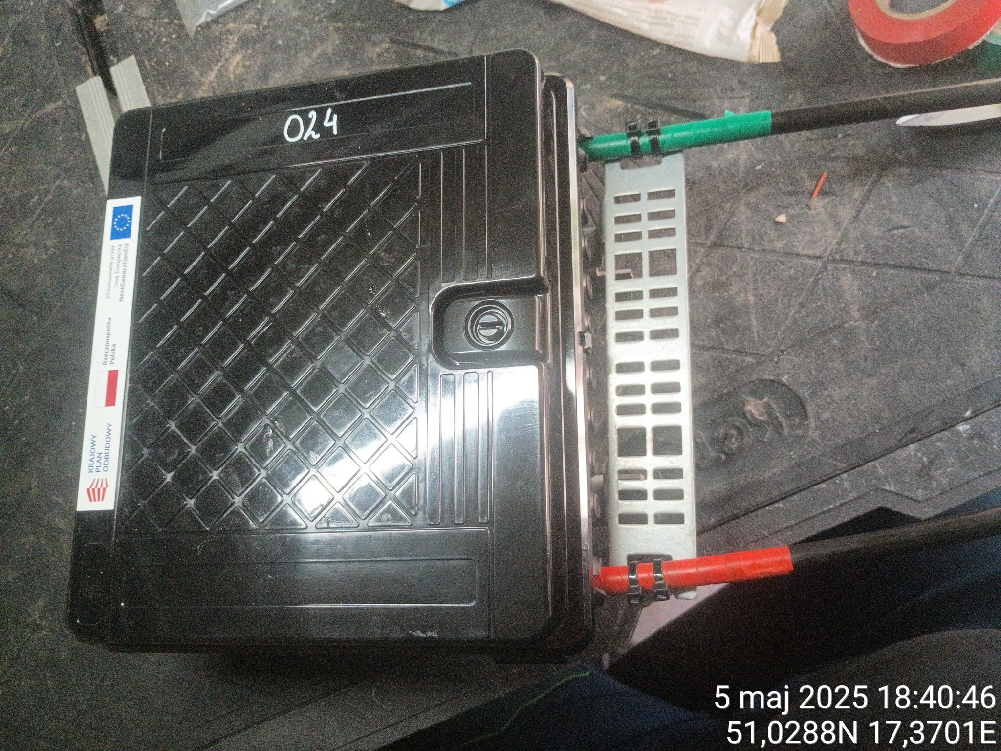 Czarna skrzynka telekomunikacyjna z kablami zabezpieczonymi opaskami, widoczne oznaczenia 'Krajowy Plan Odbudowy' i 'NextGenerationEU'.