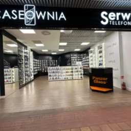 Wejście do sklepu Caseownia Serwis Telefonów z szerokim asortymentem etui i akcesoriów do telefonów, widoczne półki z produktami oraz logo Panzer Glass.