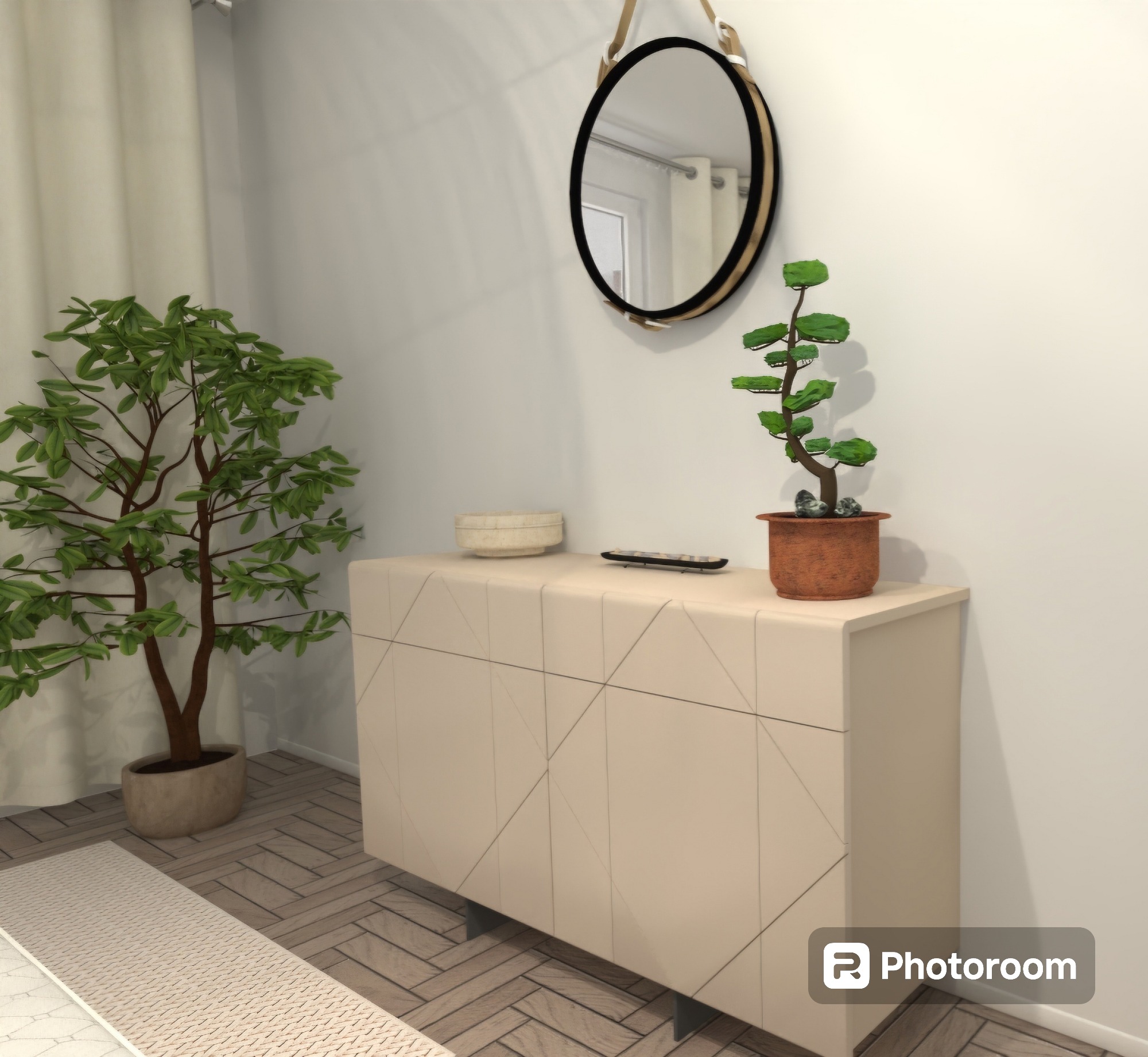 Nowoczesna komoda z geometrycznym wzorem, okrągłe lustro wiszące na ścianie, bonsai w terakotowej doniczce, miska i pilot na blacie, duża roślina doniczkowa obok, parkiet w jodełkę.