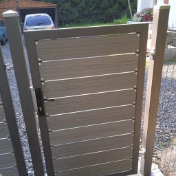 ADM Usługi Spawalnicze - Nowoczesna brama wjazdowa z poziomych paneli imitujących drewno, z metalową ramą w kolorze grafitowym, zamontowana na posesji z widocznym domem i garażem w tle.