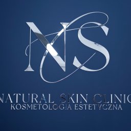 NATURAL SKIN CLINIC - salon kosmetyczny Kraków - Błyszczące, srebrne logo 'NS' nad napisem 'NATURAL SKIN CLINIC KOSMETOLOGIA ESTETYCZNA' na ciemnoniebieskim tle ściany.