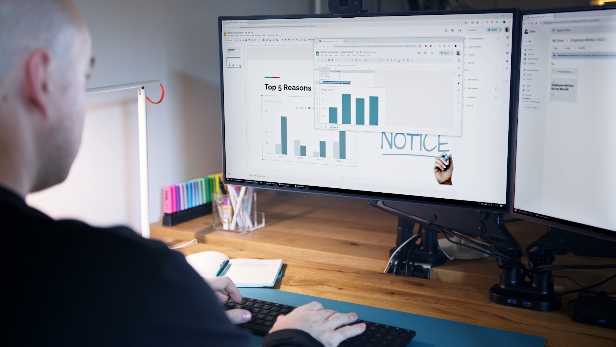 Osoba pracuje przy biurku z dwoma monitorami, na jednym z nich widoczna prezentacja z wykresem słupkowym i nagłówkiem 'Top 5 Reasons', na drugim monitorze otwarty arkusz kalkulacyjny i napis...