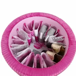 Ręcznie robiony, okrągły, tapicerowany puf w odcieniach różu, z przegródkami na buty wewnątrz, widoczne różne style i kolory obuwia.