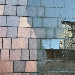 Częściowo wyczyszczona kostka brukowa z widoczną różnicą w kolorze i zabrudzeniach, gumowy but w rogu kadru.