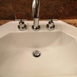 FRESH & CLEAN - Biała, ośmiokątna umywalka z chromowaną armaturą na blacie z brązowego granitu.