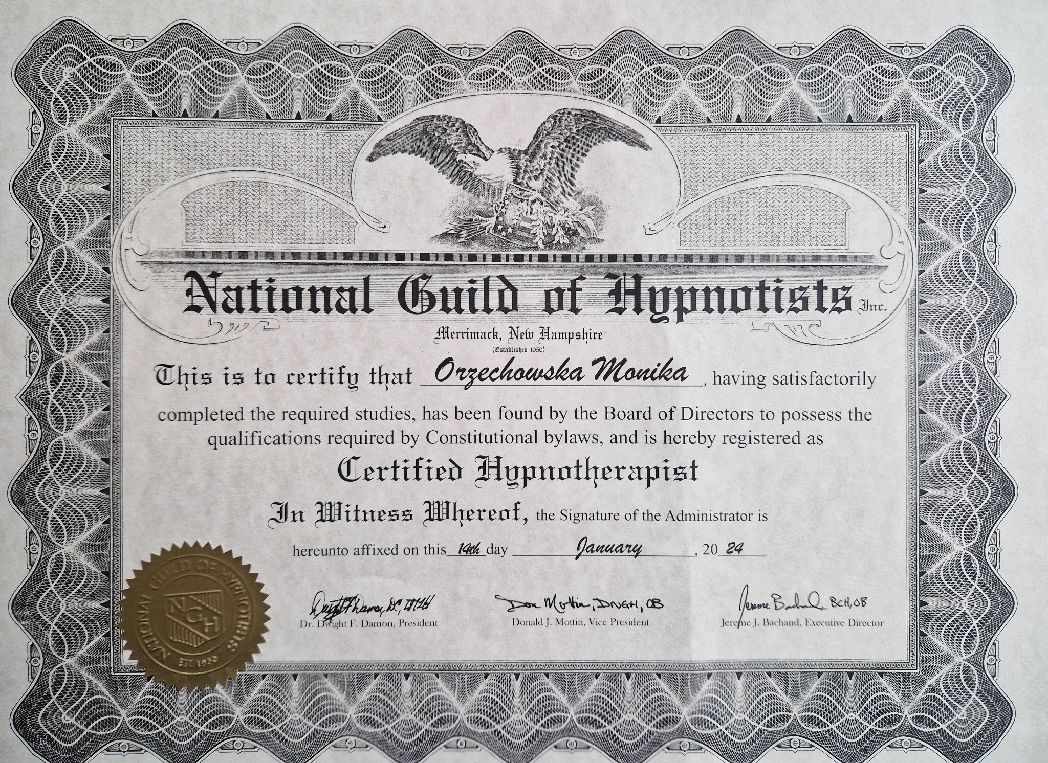Certyfikat ukończenia kursu hipnoterapii wydany przez National Guild of Hypnotists dla Orzechowskiej Moniki, z ozdobną ramką i pieczęcią.
