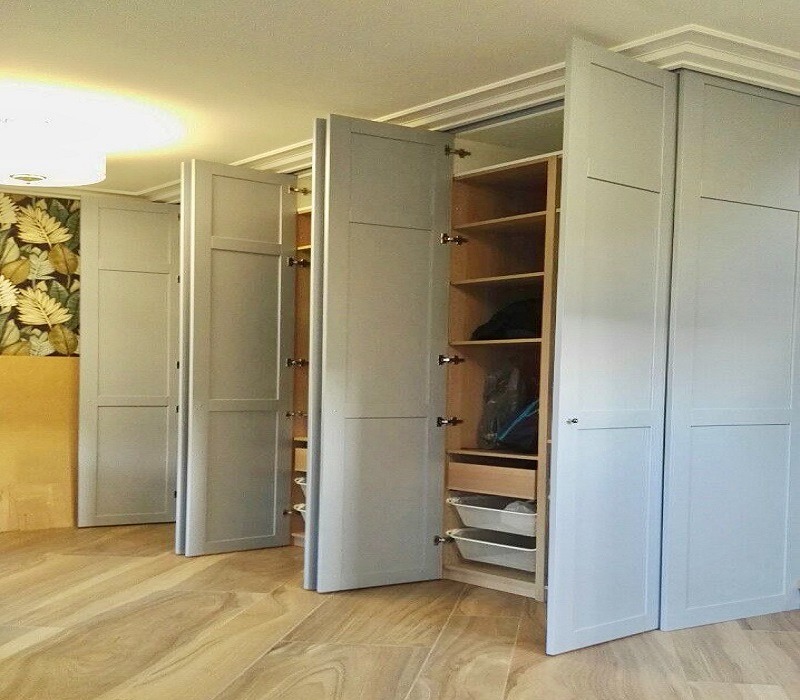 Szara szafa wnękowa z otwieranymi drzwiami, widoczne półki i kosze do przechowywania, Łódź.