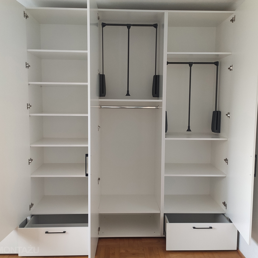 Wnętrze białej, trzydrzwiowej szafy z szufladami, półkami i pantografami na ubrania, widok z przodu na drewnianą podłogę.