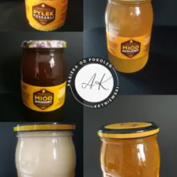 Zestaw czterech słoików z różnymi rodzajami miodu: pyłek pszczeli, akacjowy, spadziowy i rzepakowy, każdy z etykietą 'Z Polskiej Pasieki' i logo producenta w centrum kadru.