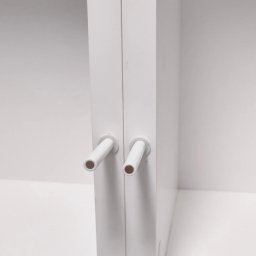 SN COMPANY SERHII NOVOMODNYI - Białe drzwi szafy z dwoma uchwytami w kształcie krótkich rurek, widoczne wnętrze szafy w tle.
