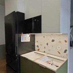 SN COMPANY SERHII NOVOMODNYI - Nowoczesna zabudowa kuchenna z czarną lodówką, białymi górnymi szafkami i zielonymi dolnymi szafkami. Uwagę zwraca nietypowa ściana nad blatem wykończona płytkami w stylu lastryko.