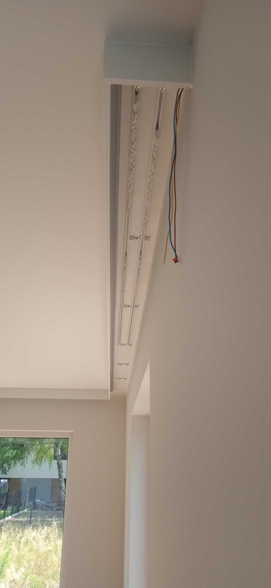 Montaż sufitu podwieszanego z oświetleniem LED, widoczne przewody elektryczne i elementy konstrukcyjne.