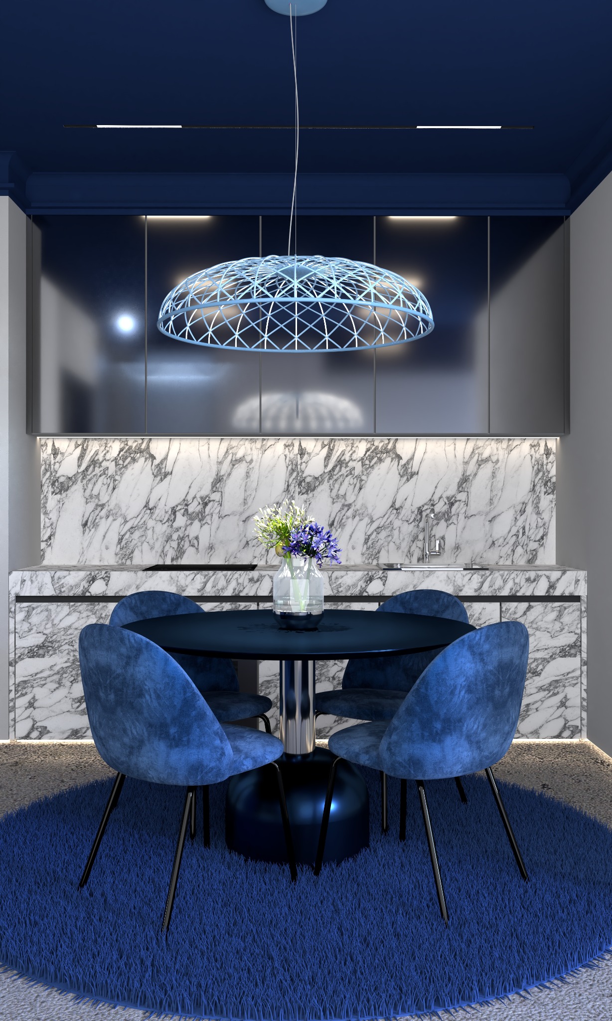 Niebieska aranżacja jadalni z okrągłym stołem, aksamitnymi krzesłami i geometryczną lampą wiszącą na tle marmurowej ściany w kuchni.