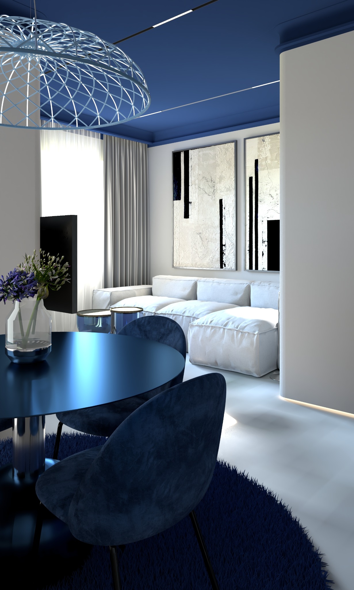 Nowoczesne wnętrze: granatowy okrągły stół z kwiatami, welurowe krzesła, biała sofa i abstrakcyjne obrazy na ścianie, oświetlenie sufitowe w kolorze indygo.