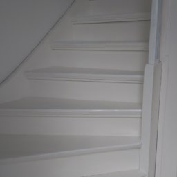 PIMMAR SPÓŁKA Z OGRANICZONĄ ODPOWIEDZIALNOŚCIĄ - Białe, drewniane schody prowadzące na górę, z widoczną ścianą i fragmentem podłogi z ciemnych płytek.