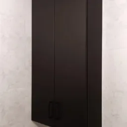 Czarna, wisząca szafka łazienkowa z matowymi frontami i minimalistycznymi uchwytami, zamontowana nad drewnianą szafką w łazience w Gruszowie, na tle ściany wyłożonej płytkami imitującymi marmur.