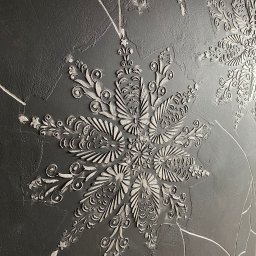 Virya- Wnętrza Liliana Strzelecka - Szara ściana z dekoracyjnymi, wypukłymi wzorami w kształcie stylizowanych kwiatów i roślin, wykonana techniką strukturalną.