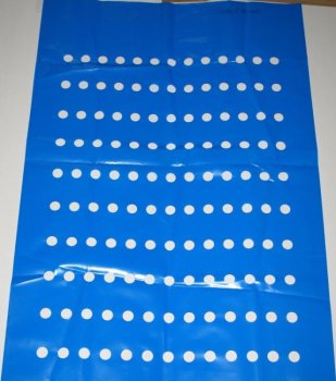 Niebieska folia perforowana z regularnie rozmieszczonymi okrągłymi otworami, widoczna faktura materiału.