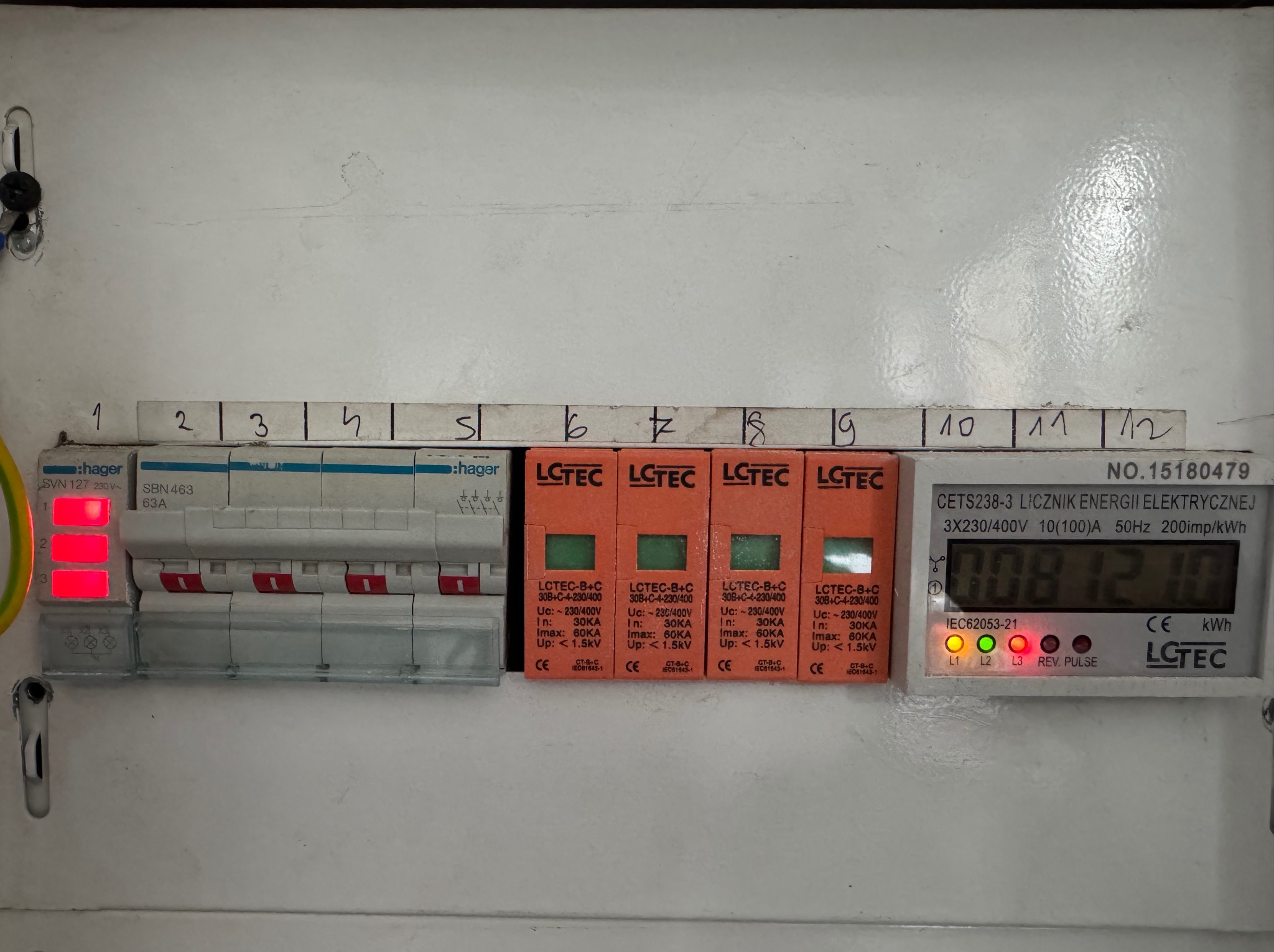 Rozdzielnica elektryczna z zabezpieczeniami przepięciowymi LCTEC, licznikiem energii i wyłącznikami Hager. Widoczne oznaczenia i parametry urządzeń.