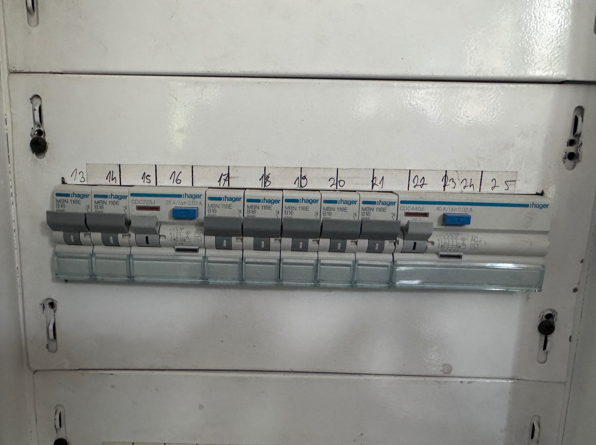 Tablica rozdzielcza Hager z bezpiecznikami oznaczonymi numerami 13-25. Widoczne modele MBN 116E B16 i CDC225J. Szare przełączniki w pozycji wyłączonej. Biała obudowa.