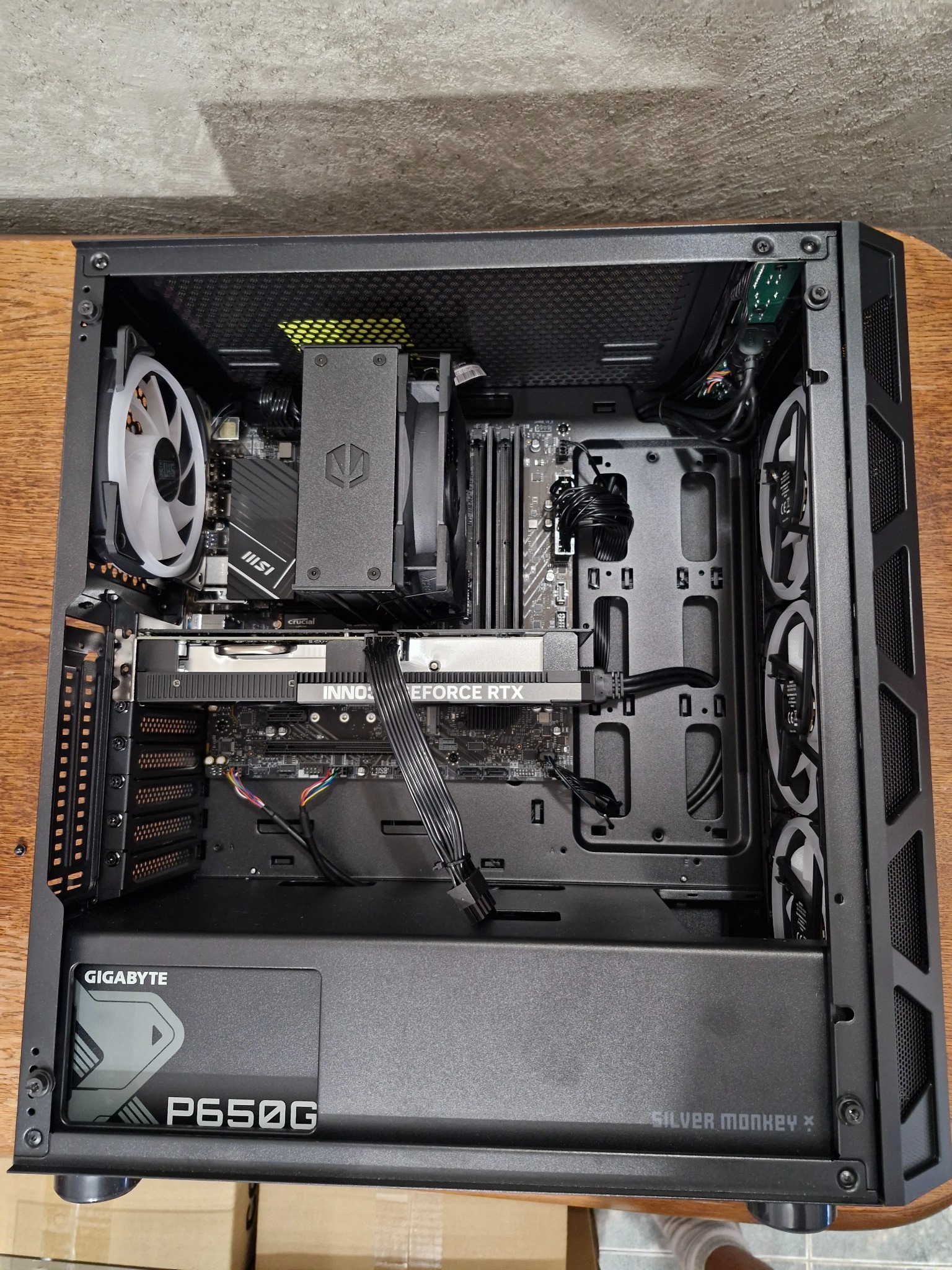 Wnętrze czarnej obudowy komputera stacjonarnego z widoczną kartą graficzną Inno3D GeForce RTX, płytą główną MSI, chłodzeniem procesora Silver Monkey X oraz zasilaczem Gigabyte P650G.