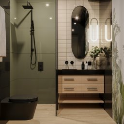 NAVRO. - Studio Projektowe - mgr inż. arch. Piotr Nawrocki - Nowoczesna łazienka z czarną armaturą, owalnym lustrem podświetlanym LED, drewnianą szafką pod umywalką i ścianą z motywem roślinnym.
