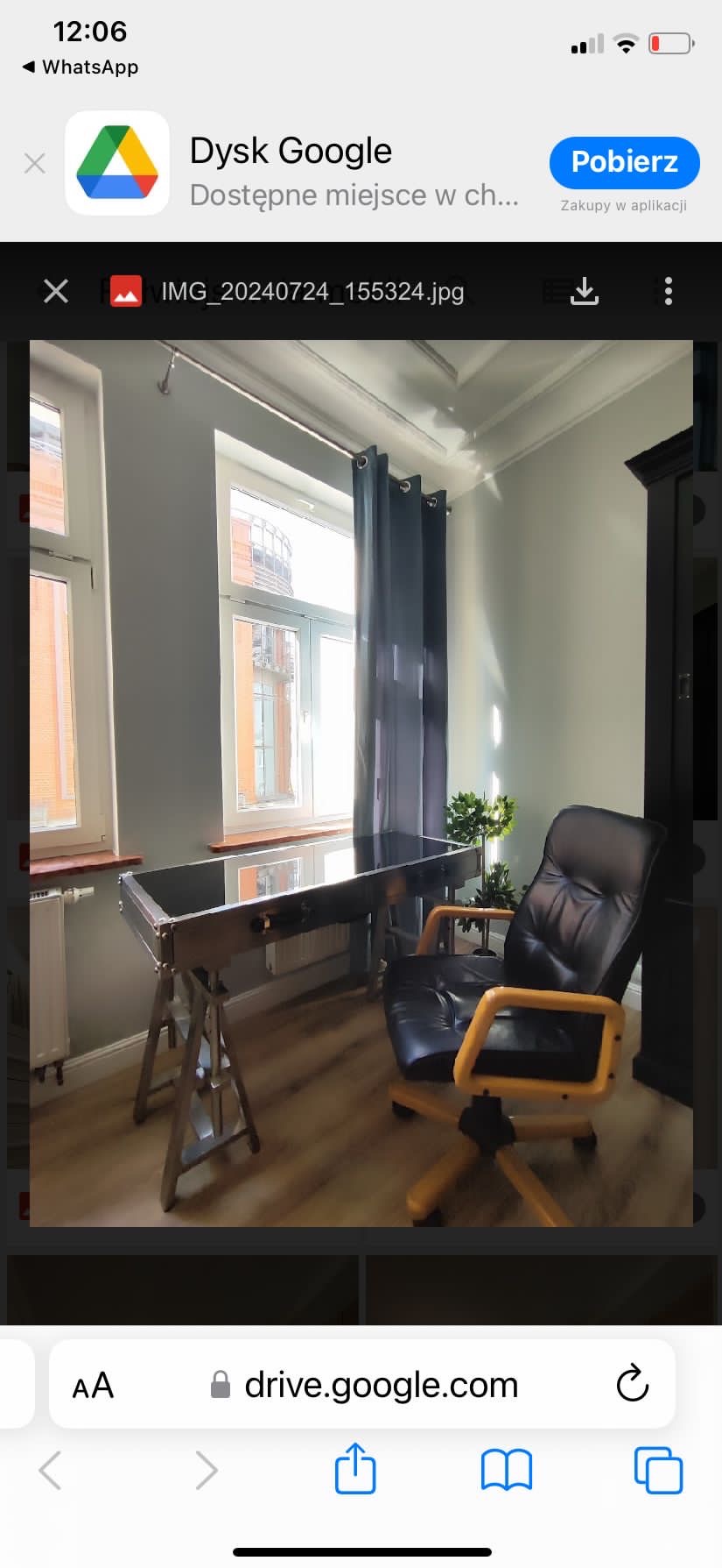 Szare ściany i drewniana podłoga w pokoju w Poznaniu z nowoczesnym biurkiem na metalowych nogach, czarnym fotelem obrotowym i rośliną doniczkową.