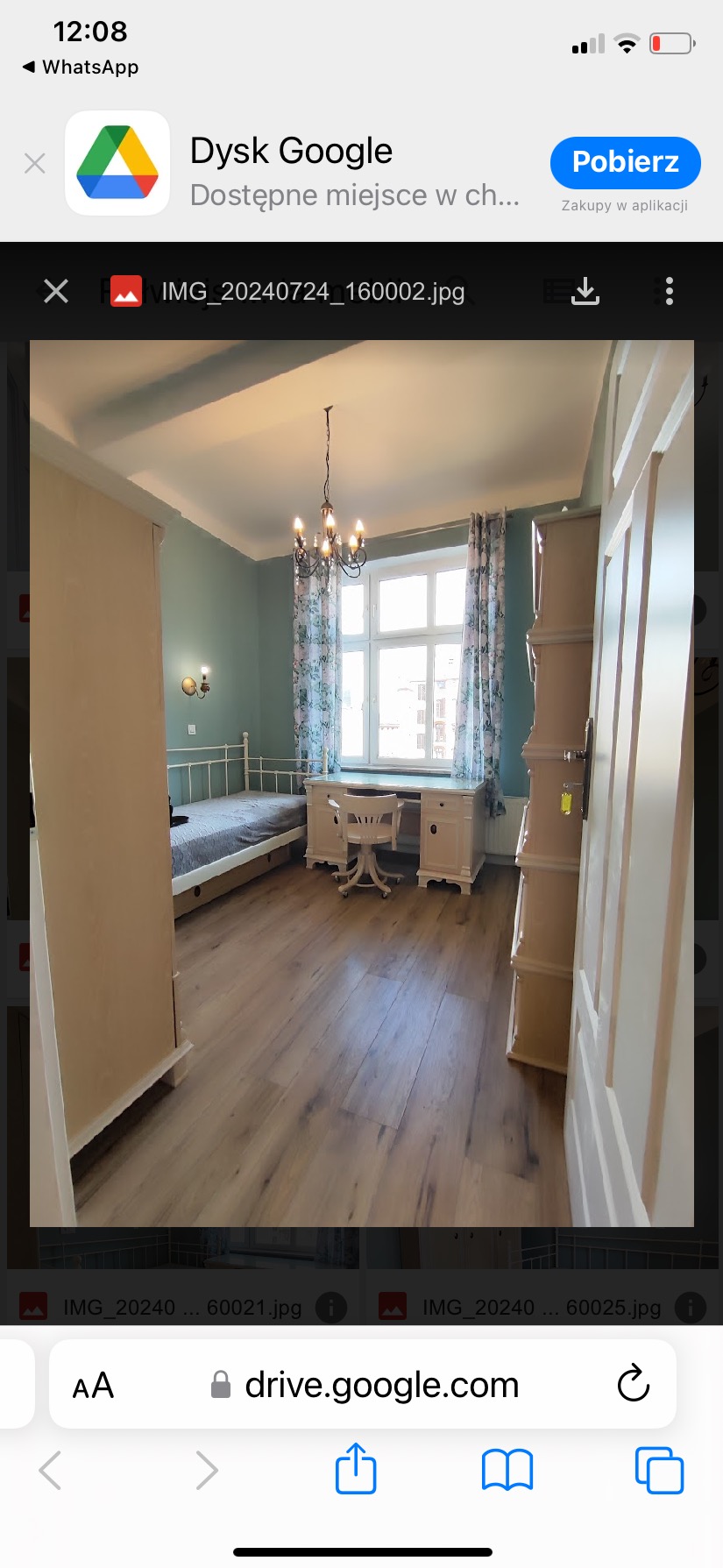 Pokój po remoncie z drewnianą podłogą, pomalowanymi na jasnozielono ścianami, białymi meblami i żyrandolem w stylu retro.