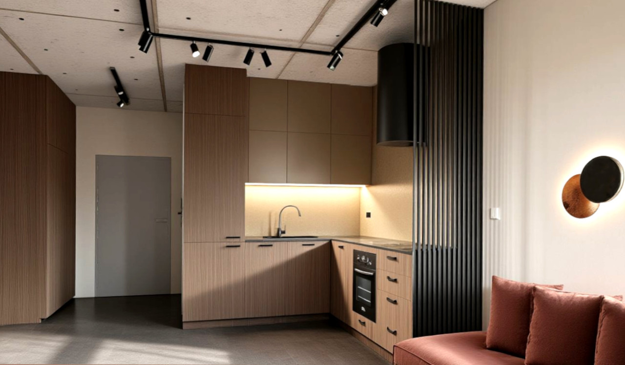 Nowoczesna kuchnia z drewnianymi frontami, czarnym okapem i oświetleniem punktowym. Minimalistyczny design z elementami dekoracyjnymi, jak lampa ścienna.