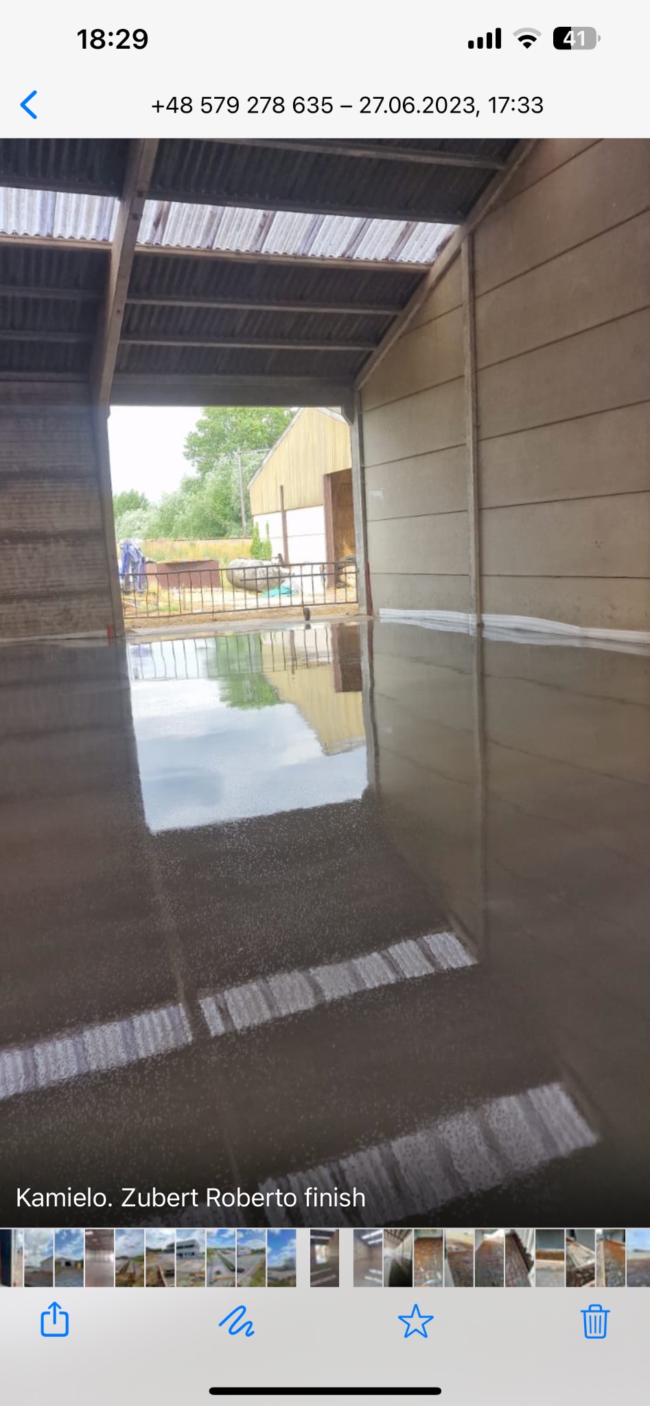 Świeżo wylana, błyszcząca posadzka przemysłowa wewnątrz budynku z betonowymi ścianami, widoczne odbicie zewnętrznego otoczenia w mokrej powierzchni.