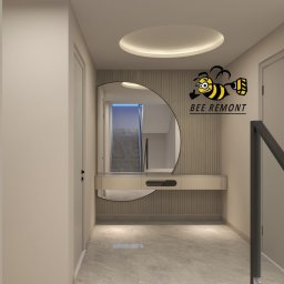 BEE REMONT ANIS DJEBAILI - Wnętrze przedpokoju z lustrem w kształcie półkola, konsolą i dekoracyjną ścianą z pionowymi żłobieniami, widoczne schody w odbiciu lustra, logo firmy remontowej w prawym górnym rogu.