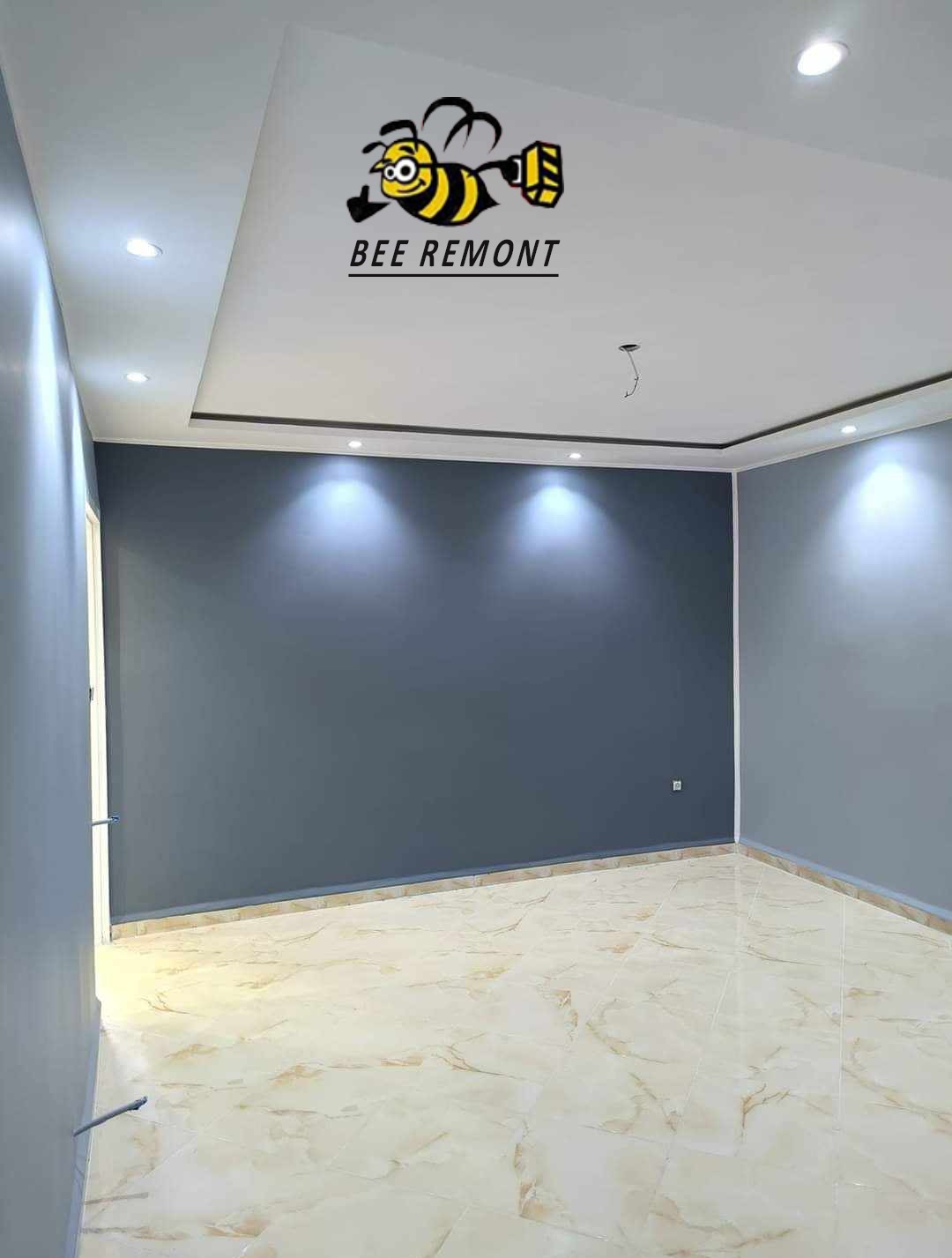 Wnętrze pokoju po malowaniu ścian na ciemny szary kolor w Pile, widoczna marmurkowa podłoga i logo firmy malarskiej na suficie.