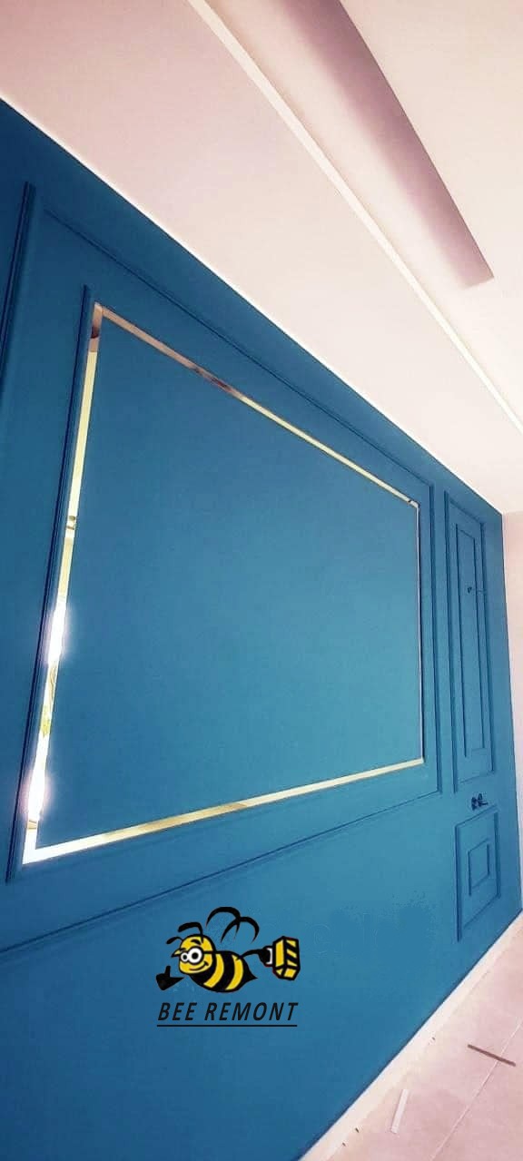 Turkusowa ściana z ozdobnymi panelami i złotymi listwami dekoracyjnymi, widoczne logo firmy 'BEE REMONT' w dolnej części.