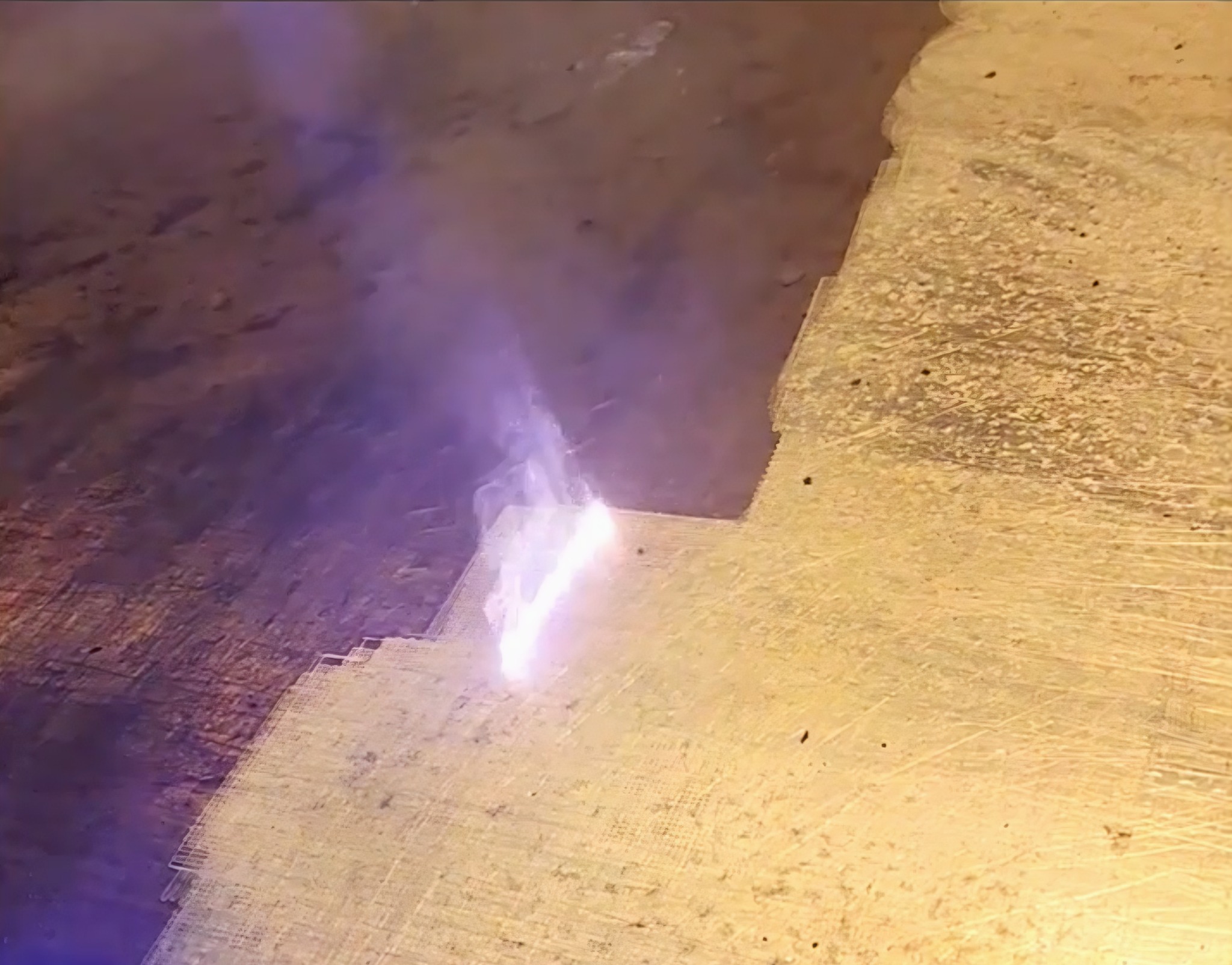 Oczyszczanie powierzchni kamiennej za pomocą palnika gazowego. Widoczne przypalenia i dym.