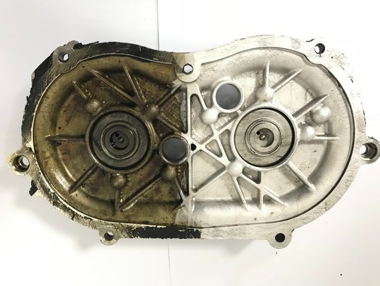 Połowa obudowy przekładni przed i po czyszczeniu, widoczne różnice w usunięciu zabrudzeń i nagaru.