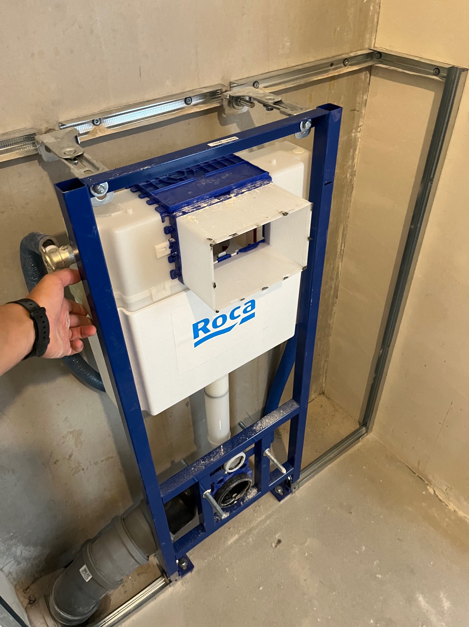 Stelaż podtynkowy WC marki Roca zamontowany w łazience w Środzie Śląskiej. Widoczna instalacja wodno-kanalizacyjna i metalowa konstrukcja mocująca.