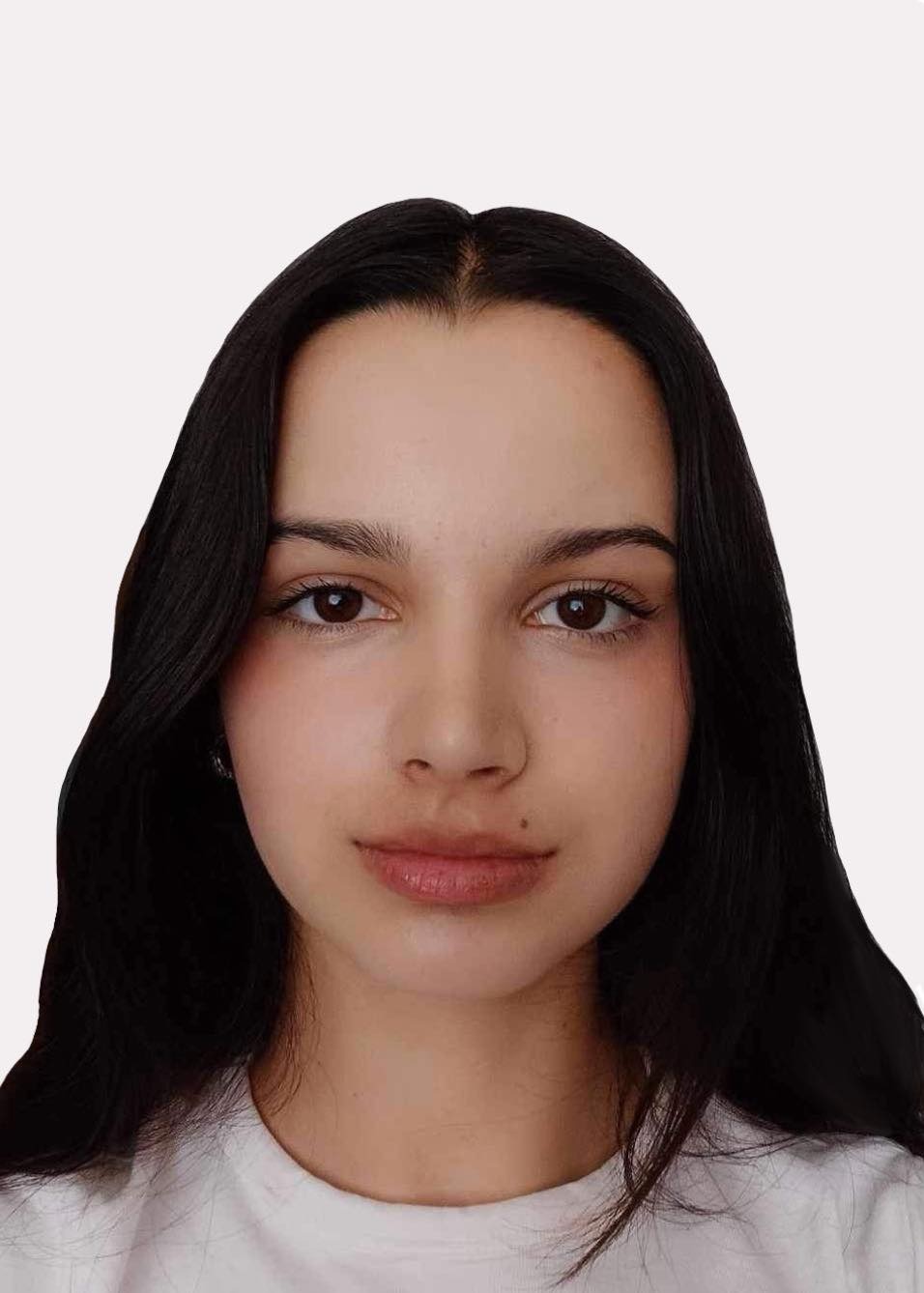 Portret młodej kobiety o ciemnych włosach, brązowych oczach i delikatnym makijażu, z widocznym znamieniem na policzku.