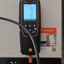 HYDRO-INSTAL-TECH SPÓŁKA Z OGRANICZONĄ ODPOWIEDZIALNOŚCIĄ - Analizator spalin Testo 310 II podczas pomiaru parametrów kotła Viessmann. Wyświetlane wartości: TS, O2, CO, udzCO, Spr n, CO2, TP. Widoczny kabel i naklejka 'Connect me!'.